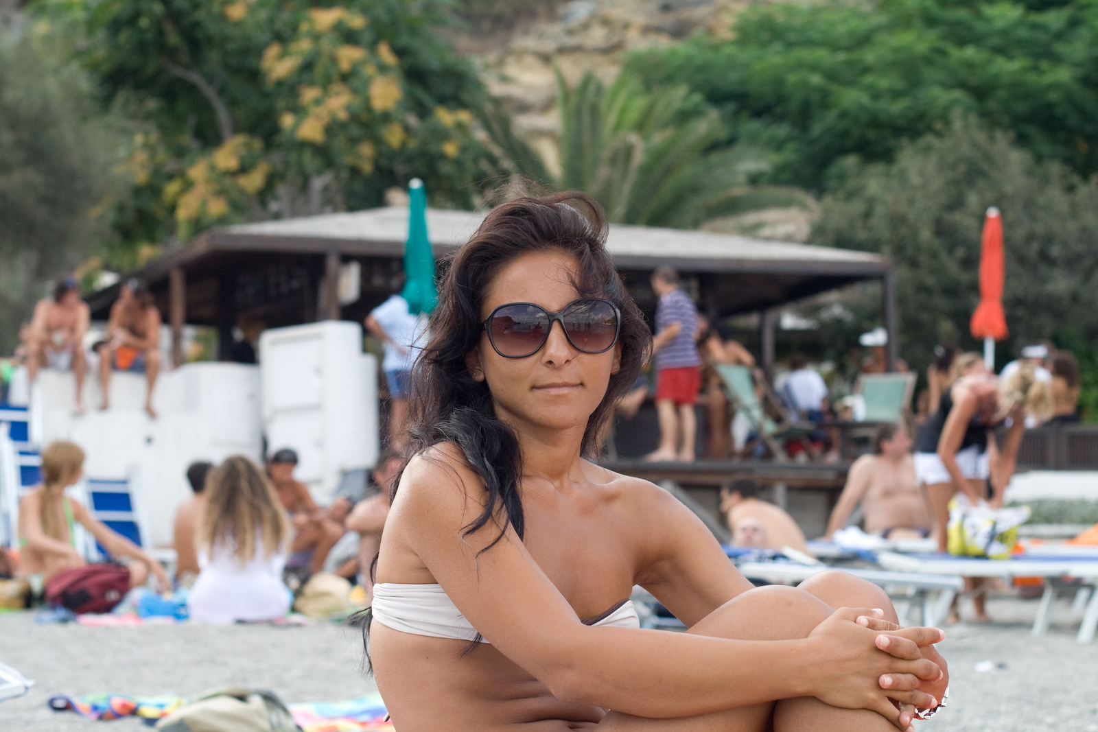 a beautiful woman in a bikini sitting on top of a towel