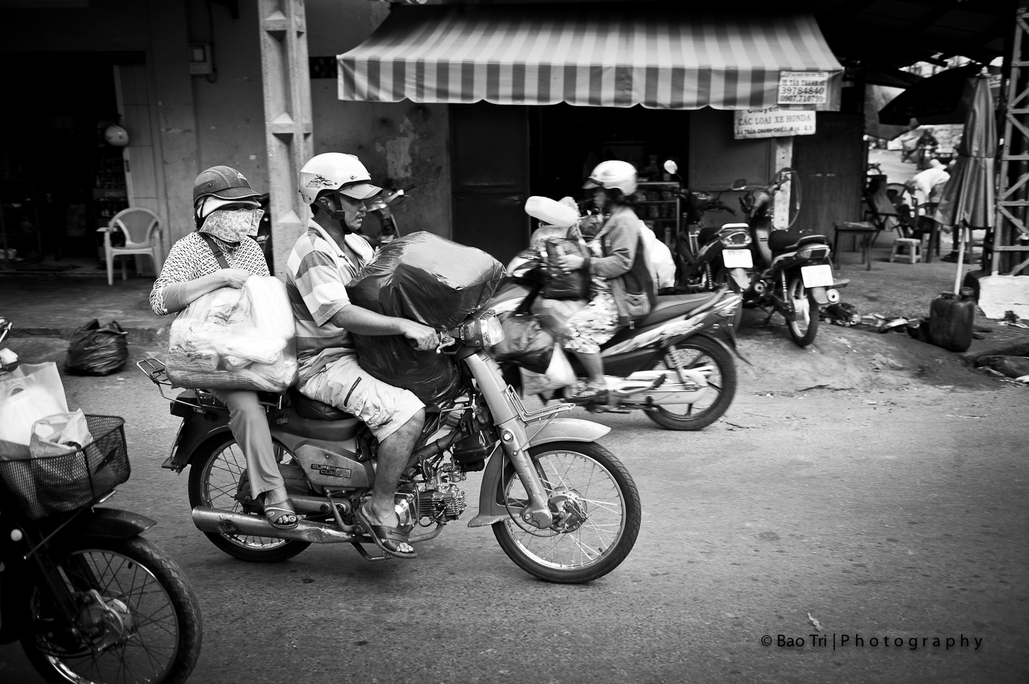 a man is riding a motorcycle with people sitting on the back