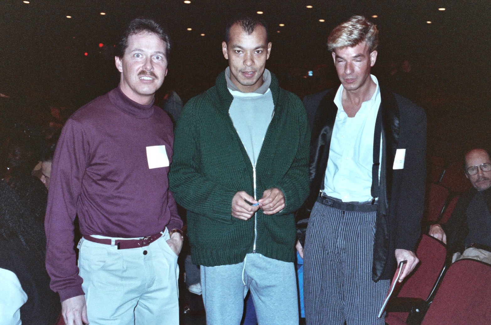 three men are standing side by side at an event