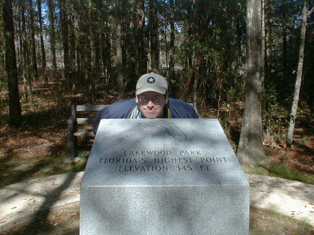 a man sitting at a monument in the woods