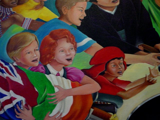 children are sitting at a table while two men look on