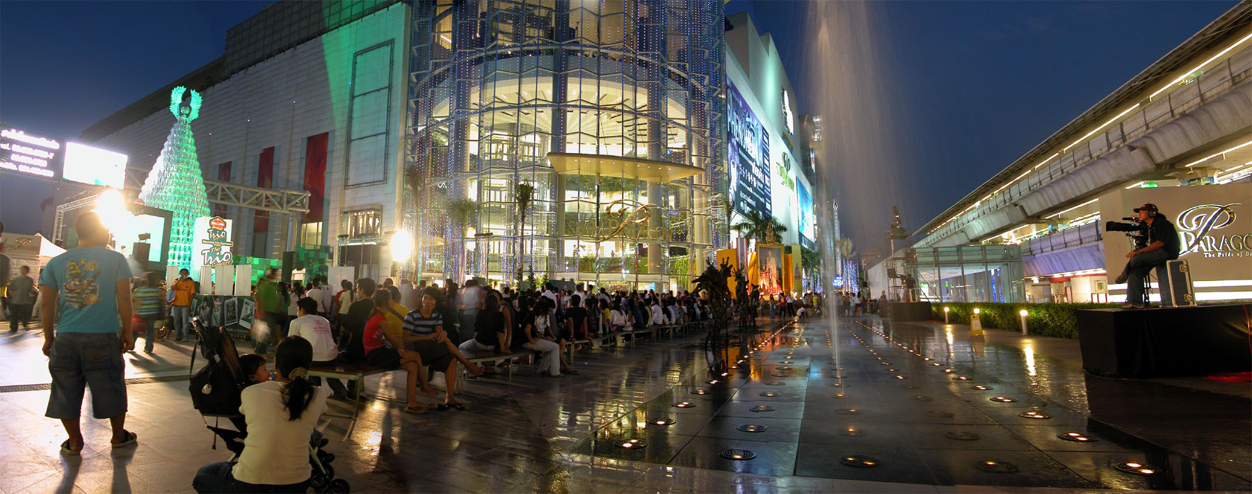 several people walking on a city street during the night