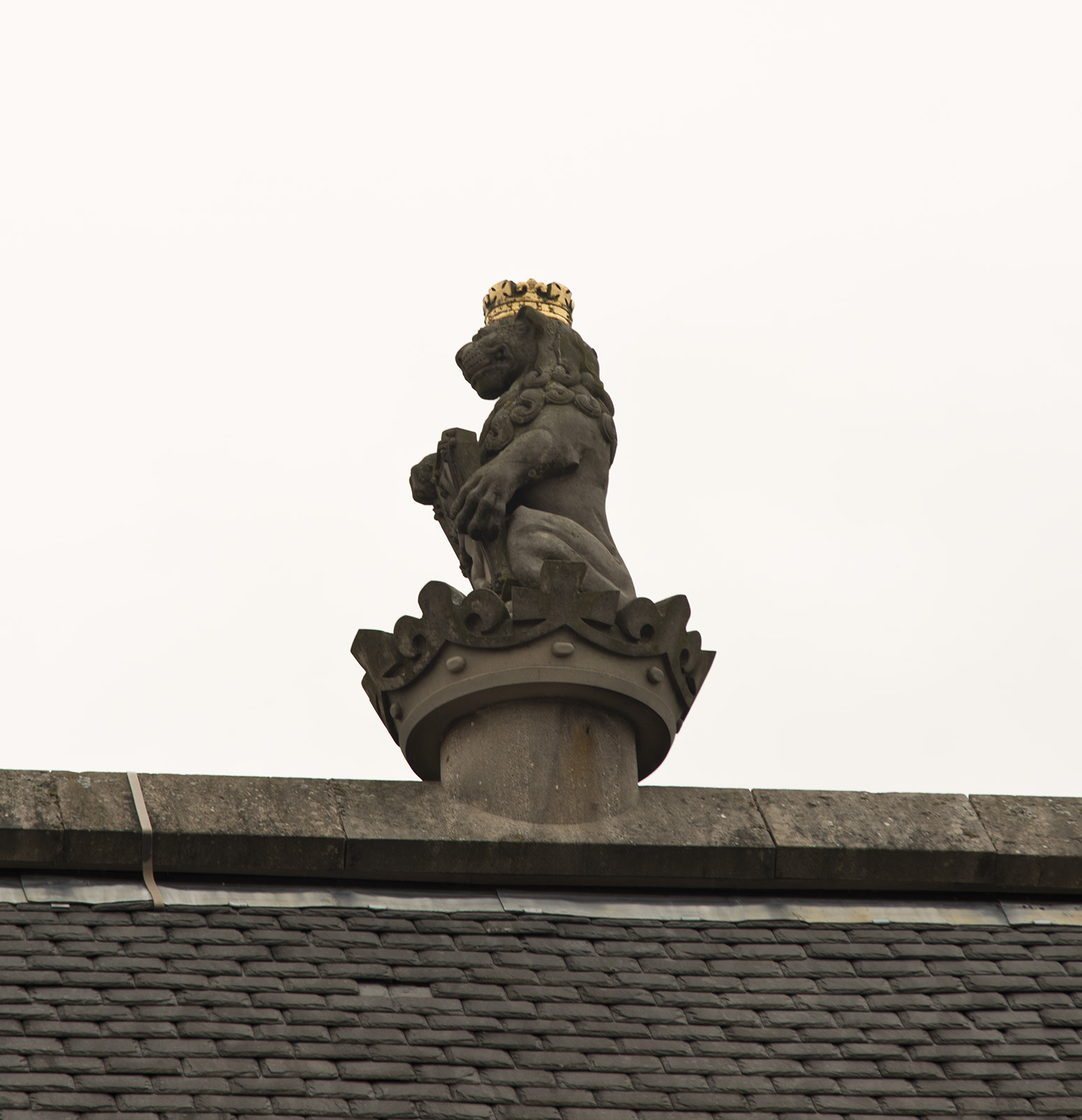 a lion statue sitting on top of a roof