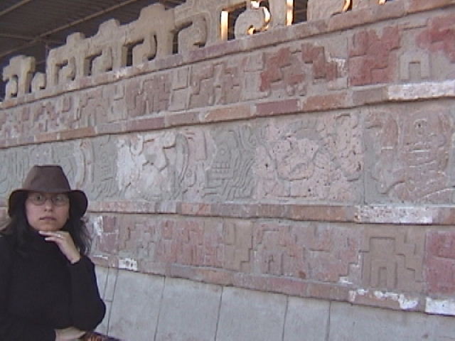 a woman leaning on a stone wall next to an arch