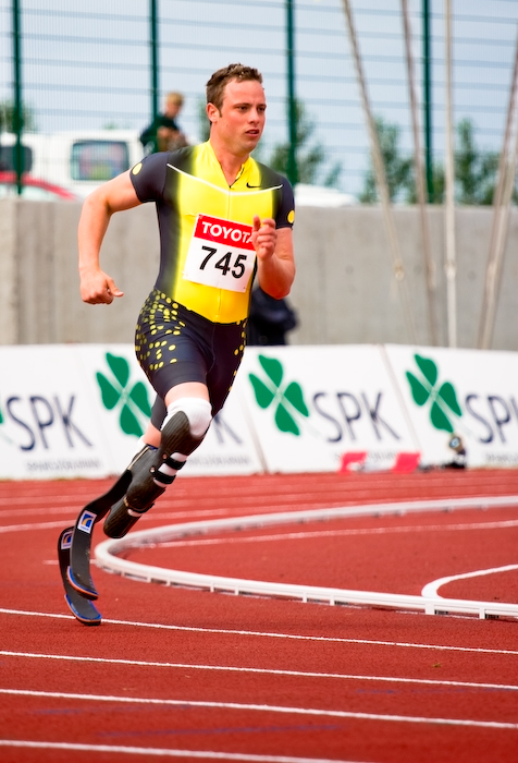 a man in black and yellow uniform running on a track