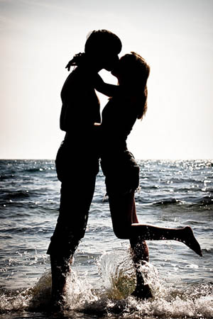 couple dancing through the water at the beach