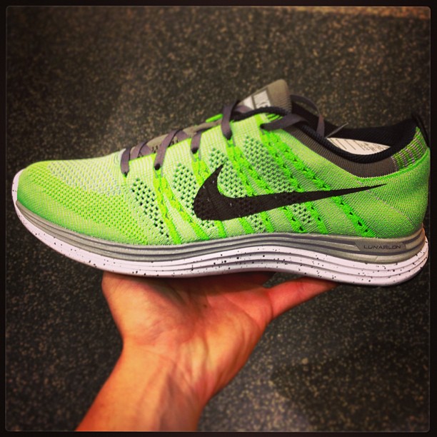 someone is holding a neon green and black nike running shoe