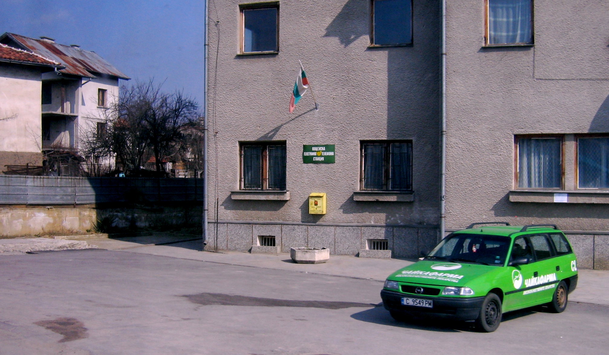 a green van is parked outside of a large building