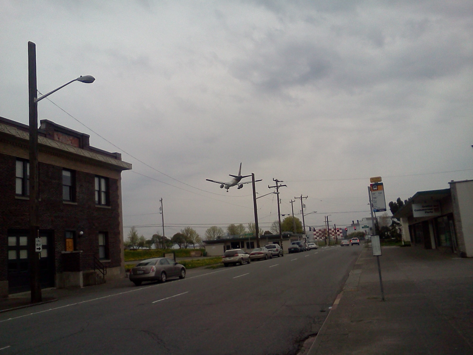 a cloudy day in an industrial area, with cars stopped on the street