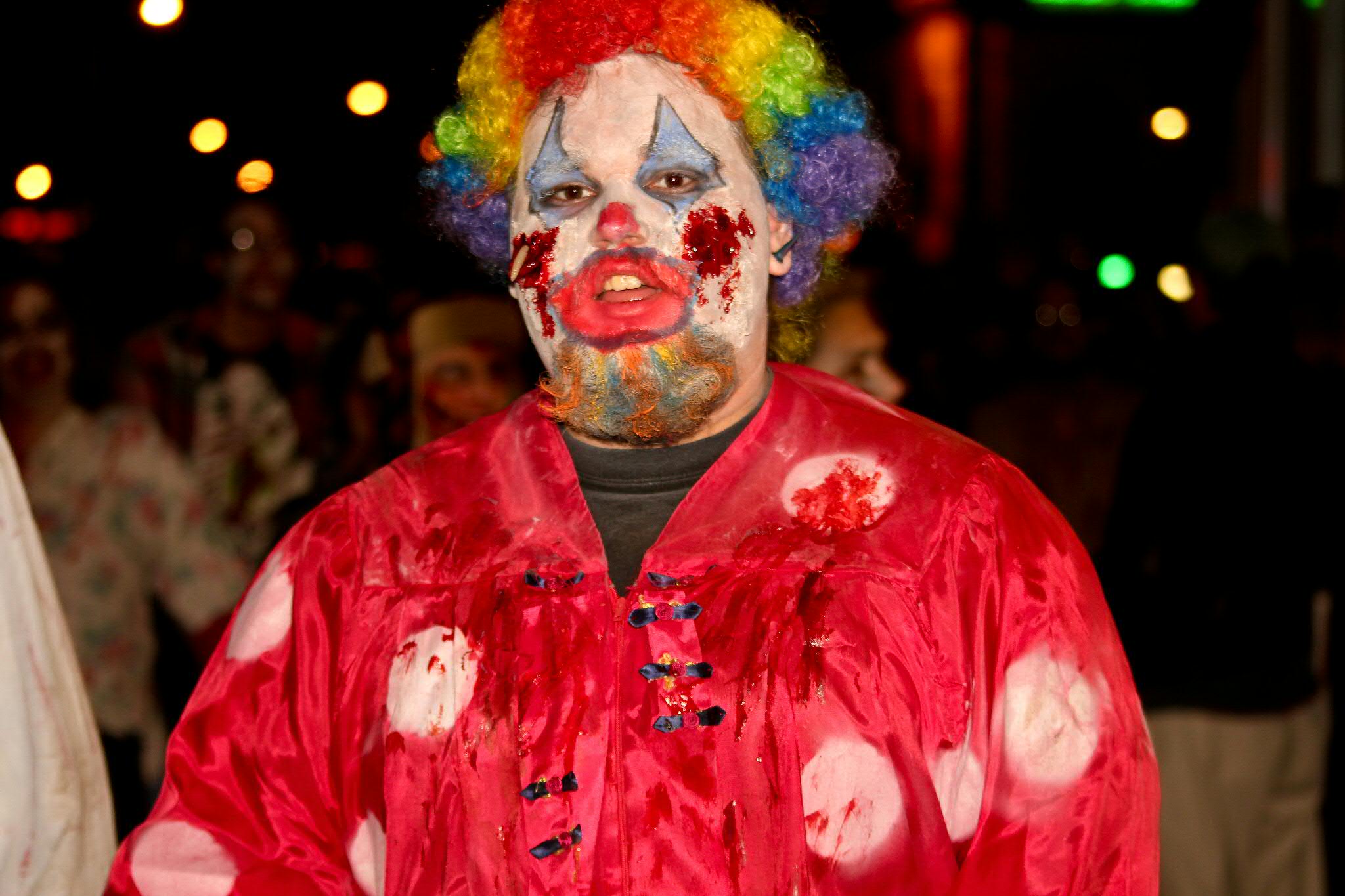 a clown dressed in clown makeup and  is posed for a po