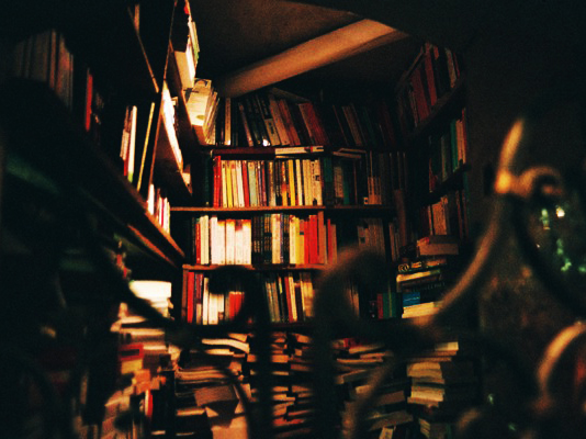 a large shelf full of books and a clock