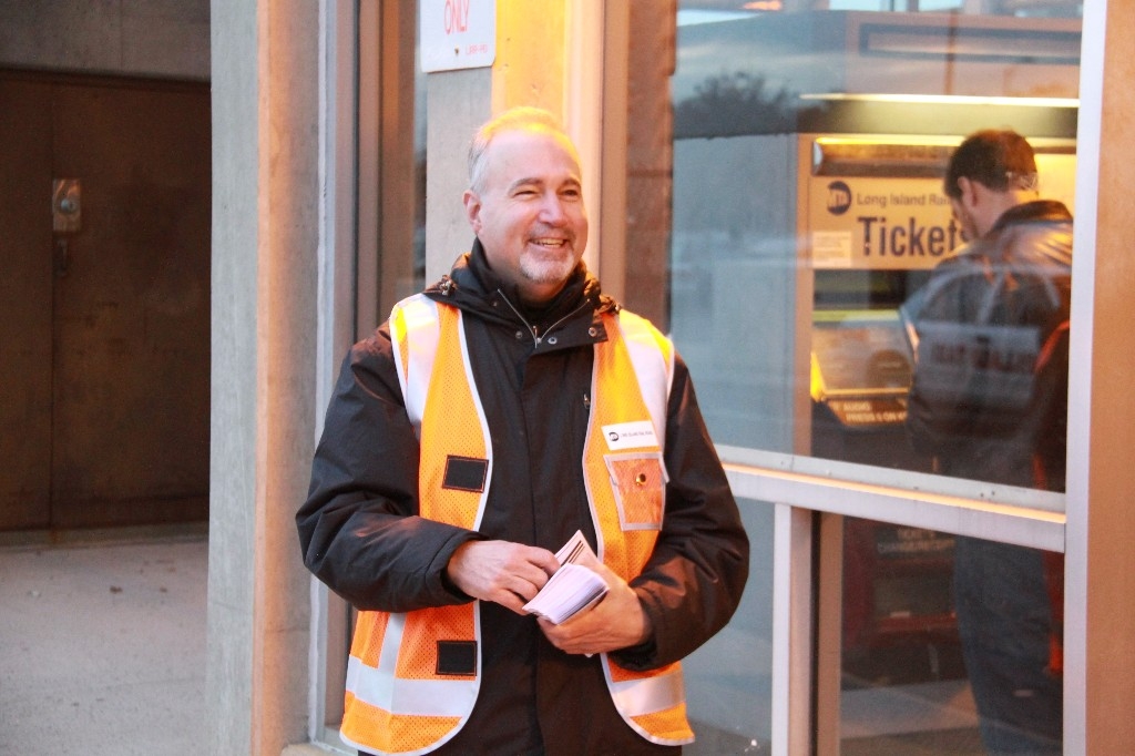 a man standing outside of a store window holding a cup