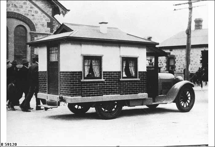 an old fashioned mobile home stands on the road