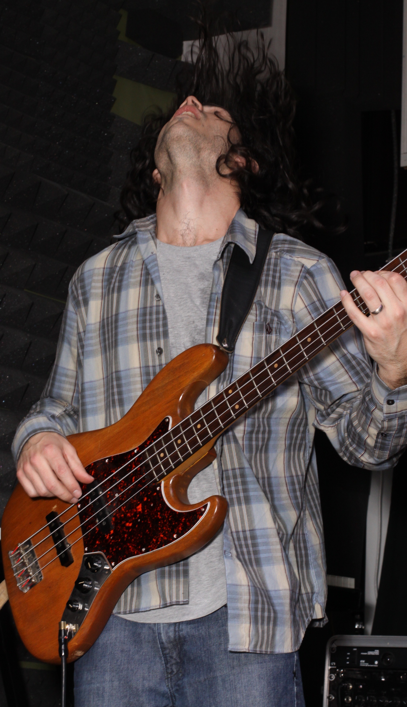 a man standing with a guitar and a microphone in front of him