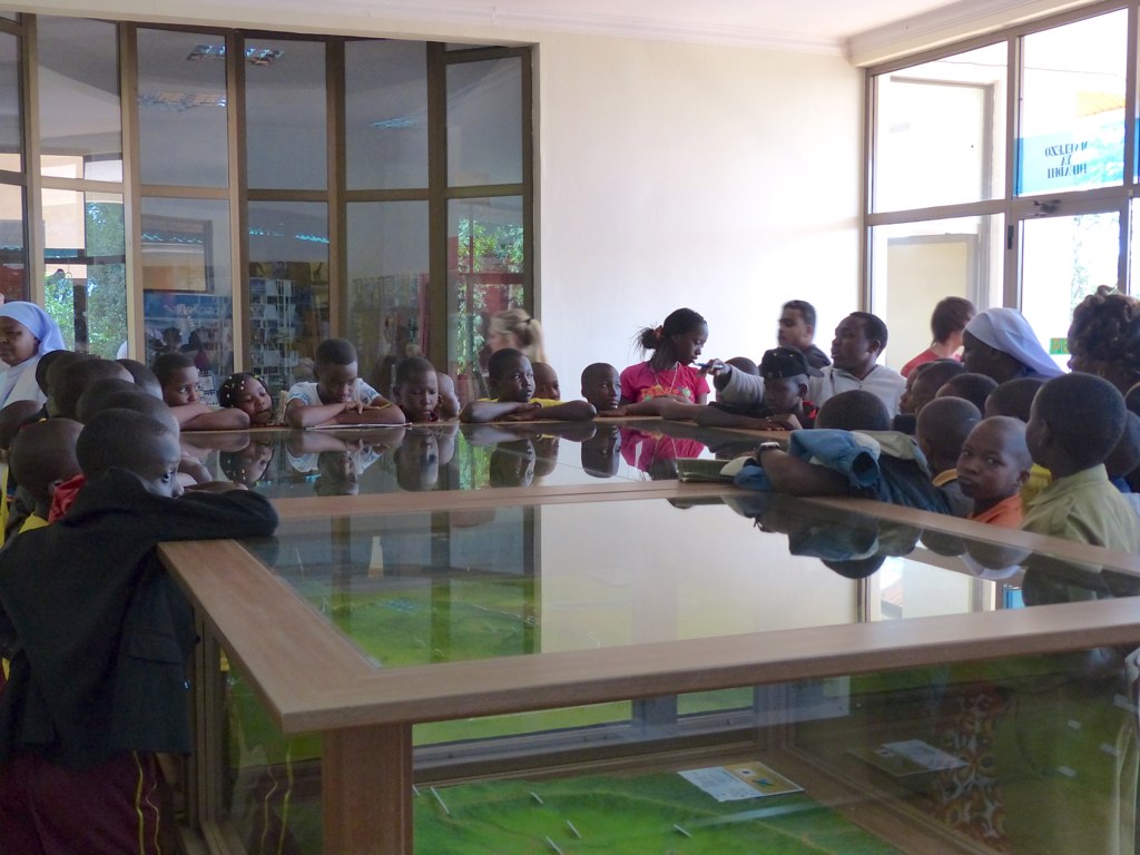 an assembly of people are sitting around a table