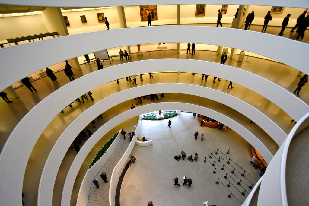 a group of people standing around a museum lobby