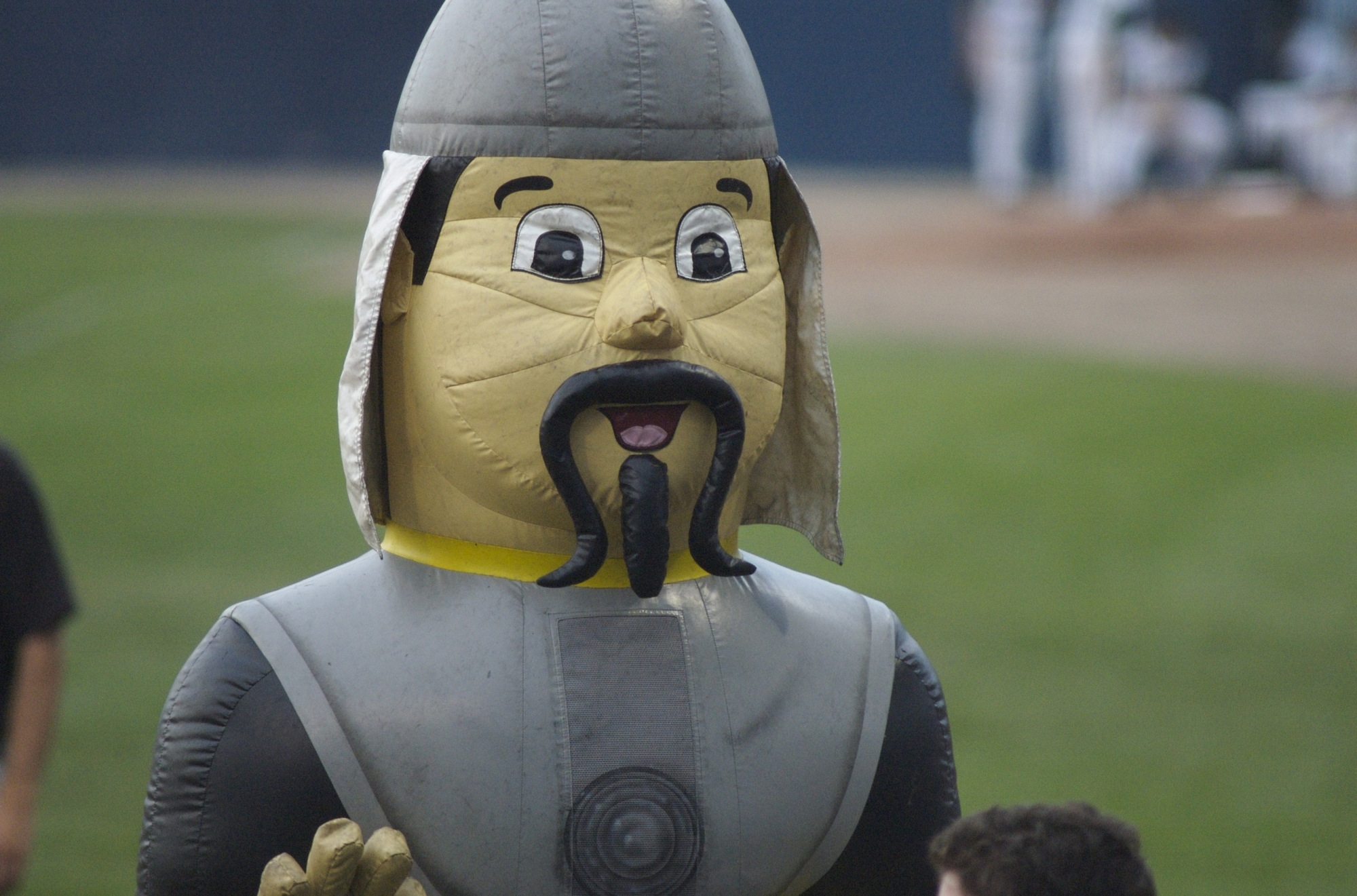 a man in a grey and black costume on top of a field