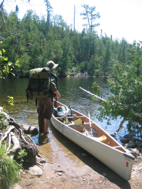 the man is walking up to the kayak