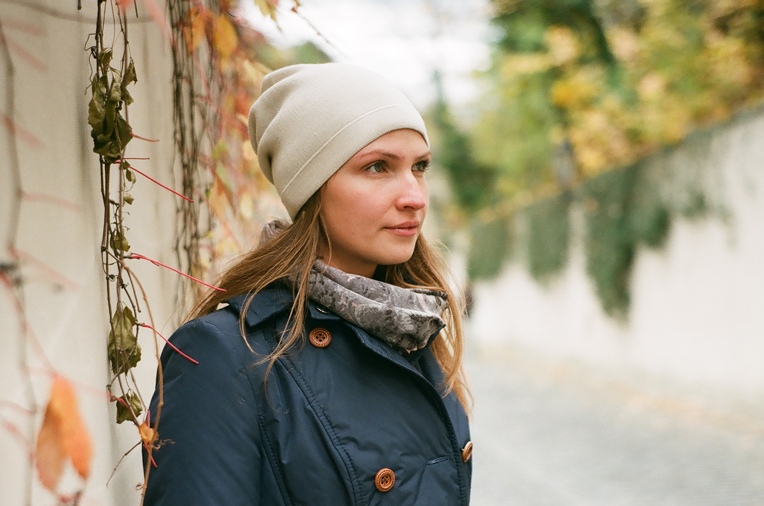 a woman with long brown hair is wearing a scarf and a winter hat