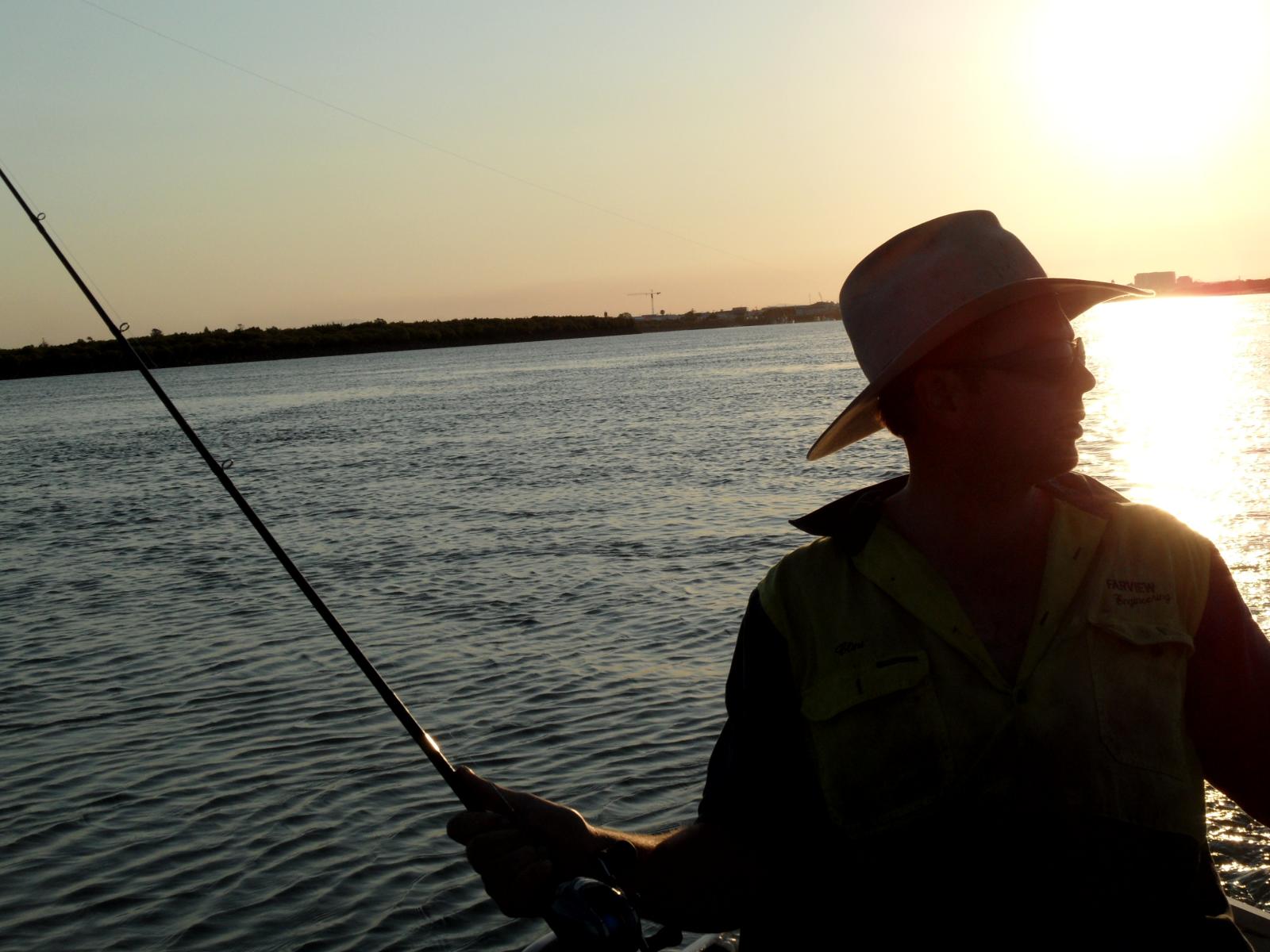 a man wearing a hat while holding onto a fishing rod
