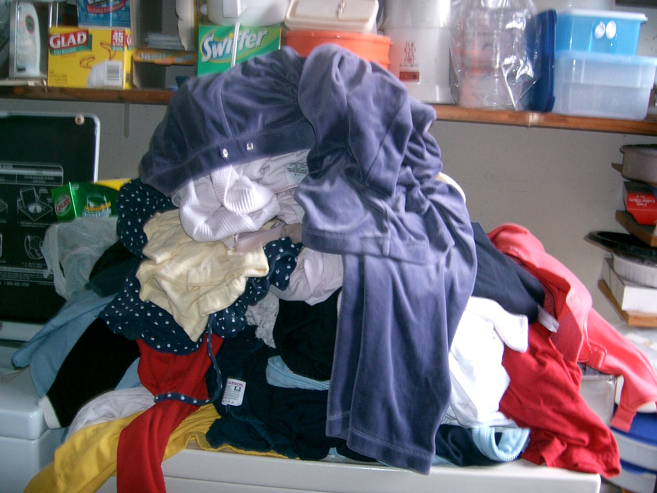 piles of clothes sitting on top of a chest