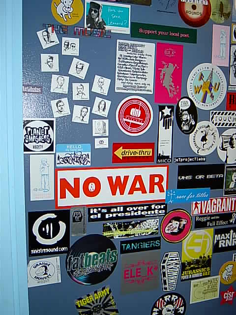 stickers and posters decorate the door of a business