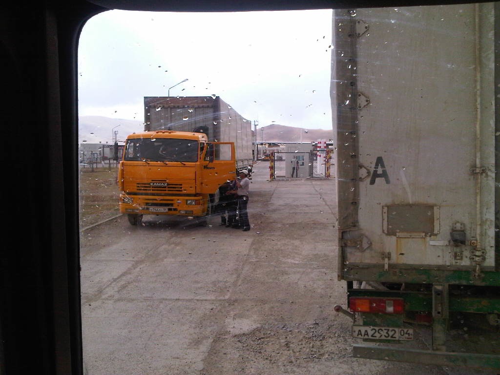 large yellow truck parked in front of a white trailer