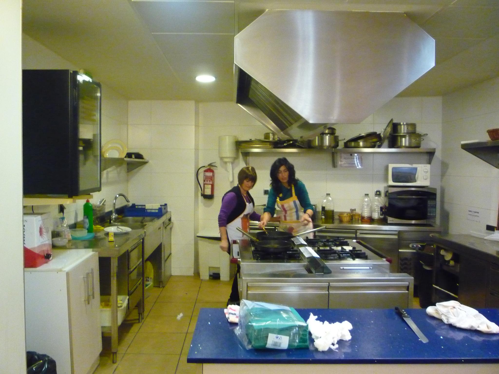two women preparing food in a small kitchen