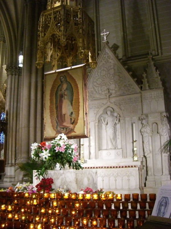 a church that has flowers and candles in front of it