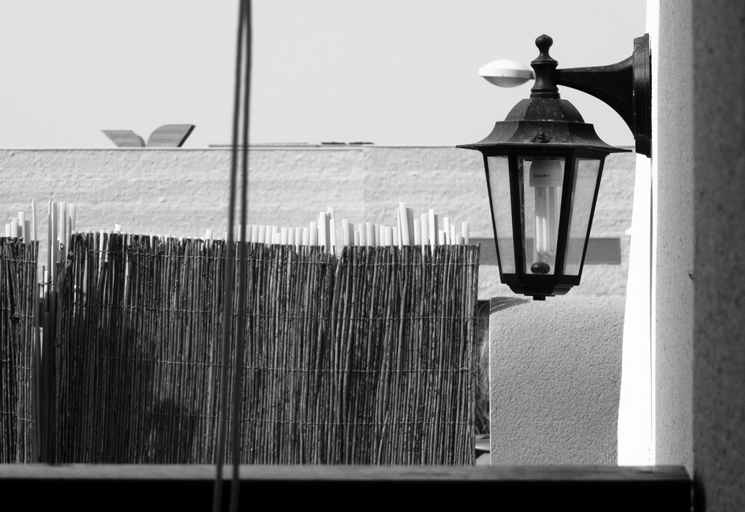 a street lamp sitting on the side of a building