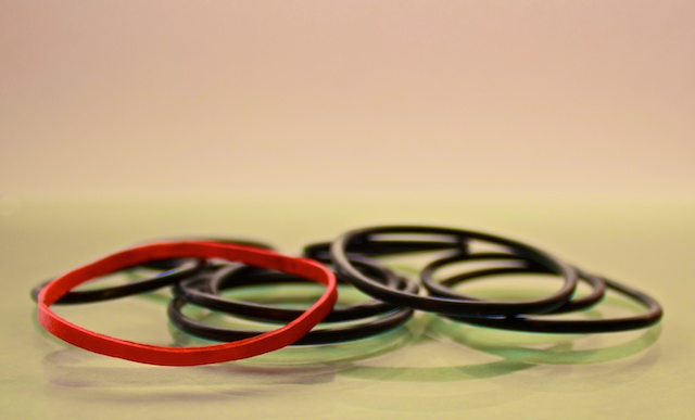 six rubber bands of various colors sitting together
