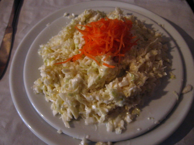 a plate with shredded carrots and coleslaw on it