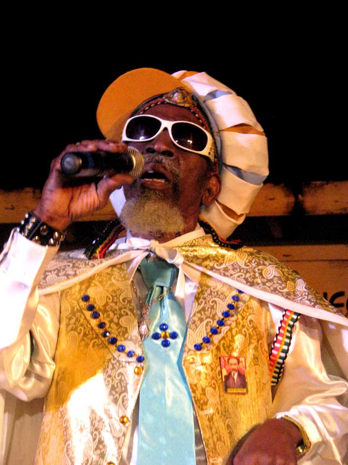 a man wearing sunglasses and a turban singing