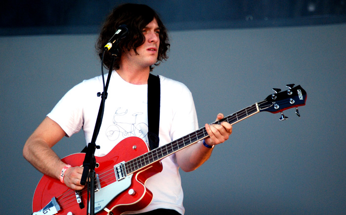 a man with long hair playing an electric guitar