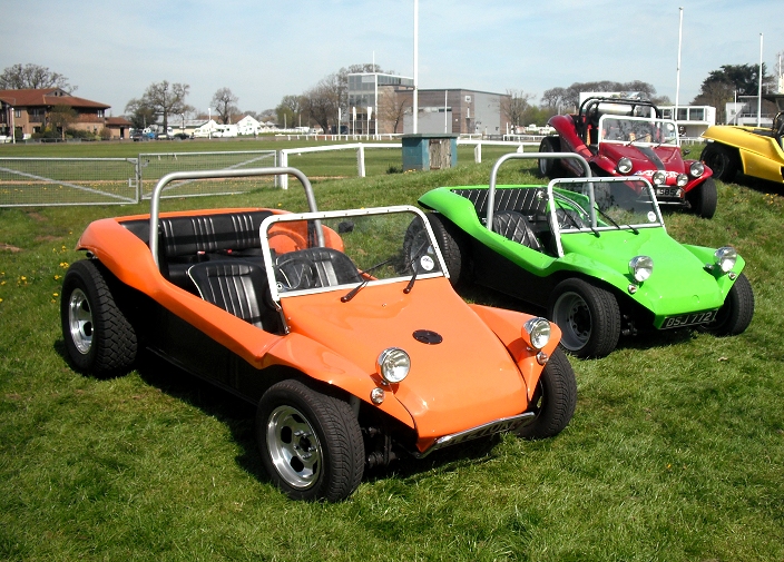 four three - wheeled cars sitting in a green field