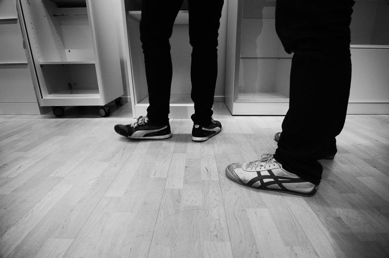 two people standing next to each other on a hard wood floor