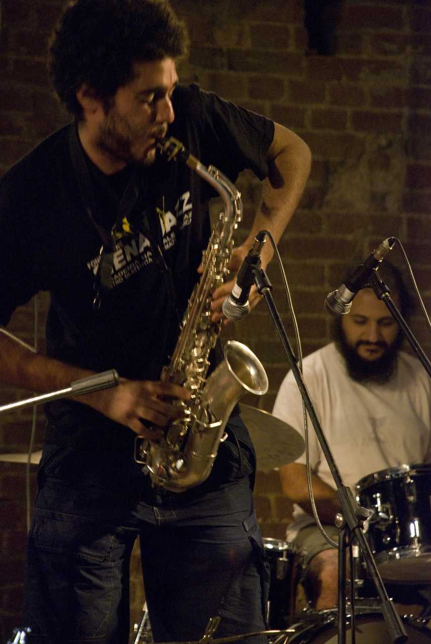 a man playing on a saxophone in front of a band