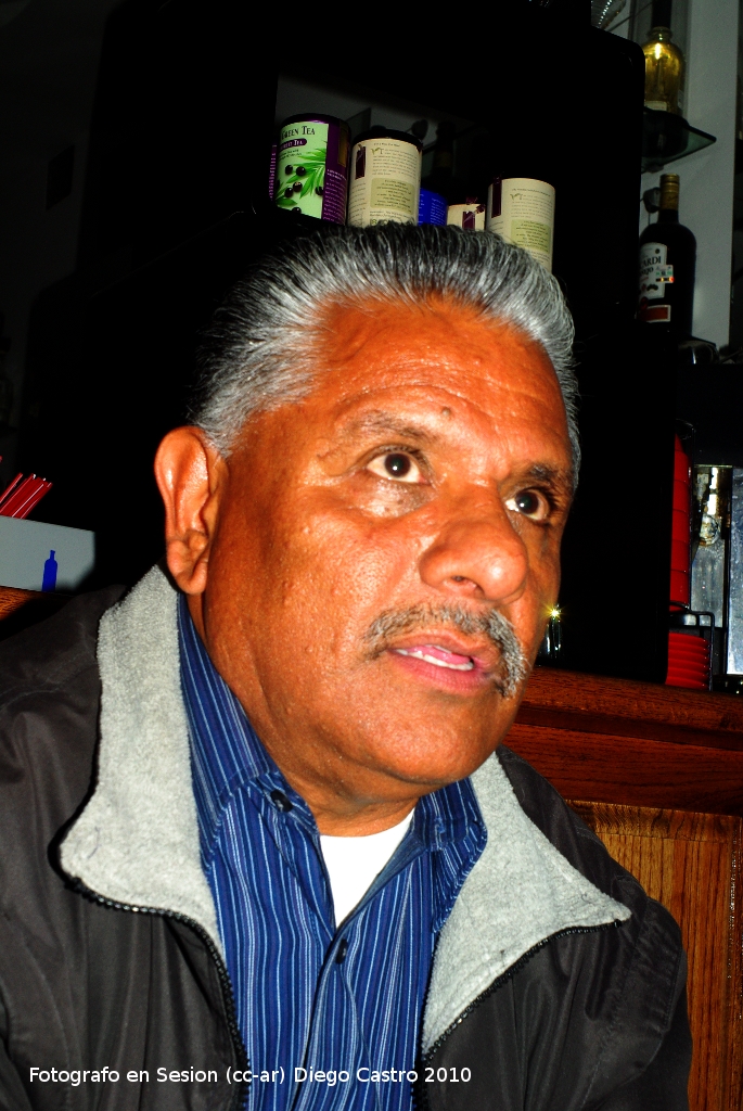 a man sitting at a table with a bottle on the back of it