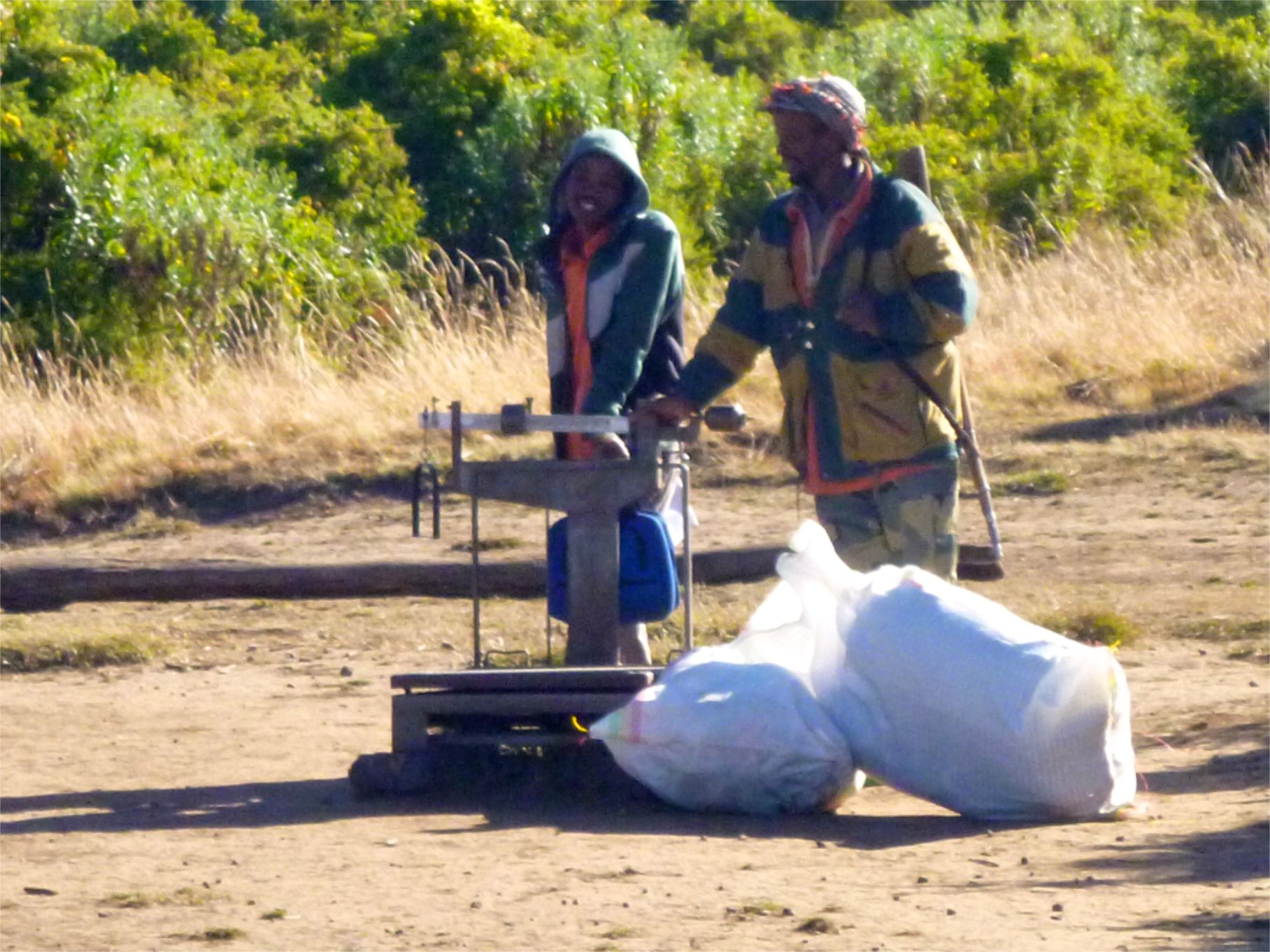 two people standing next to each other with bags