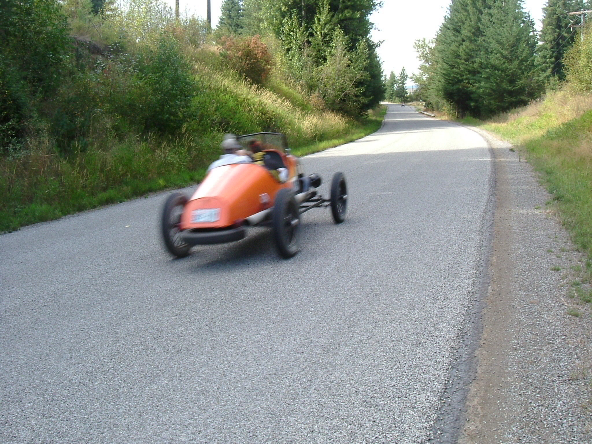 a person is driving an orange car down a street