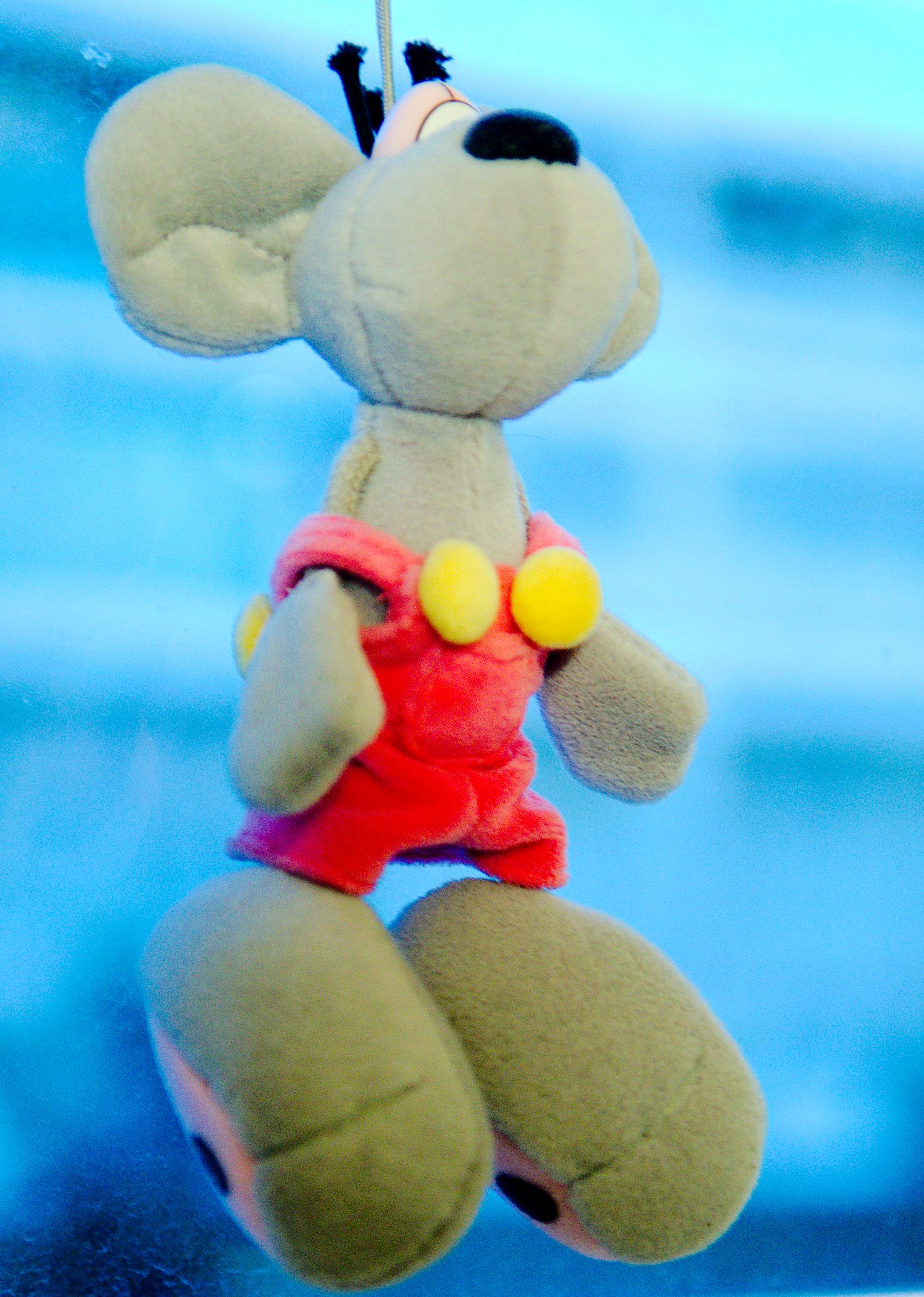 a stuffed animal mouse hanging on a string