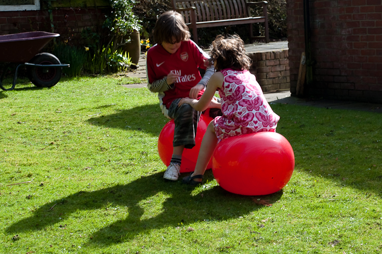two children are playing on an inflatable ball