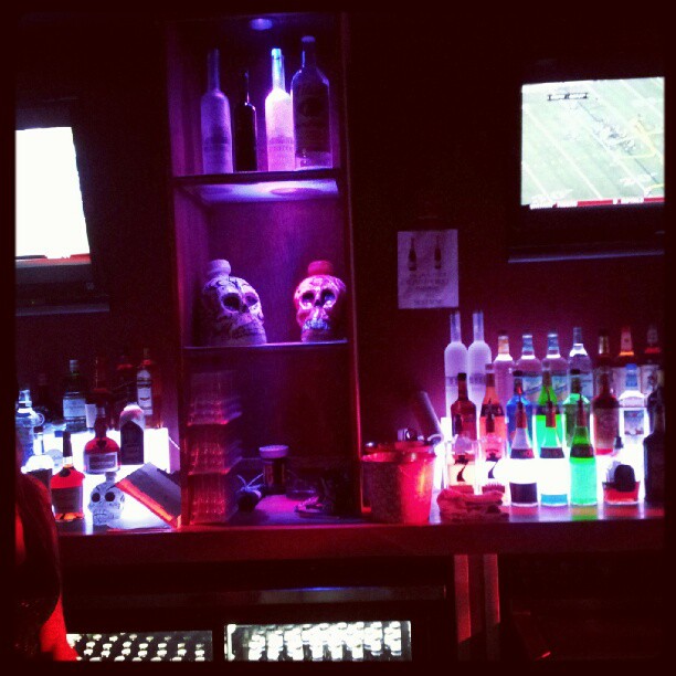 a lighted liquor bar with bottles of alcohol on shelves