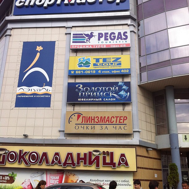 many advertising signs are seen above the facade of a business