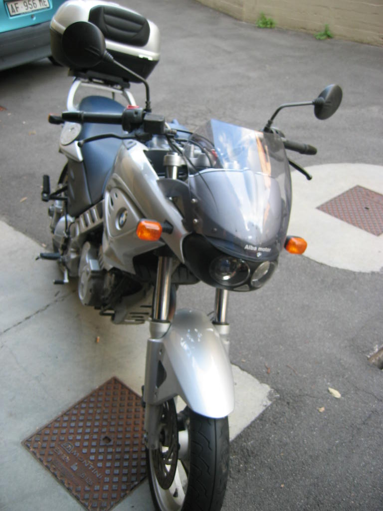 a motorcycle parked outside by a curb and car