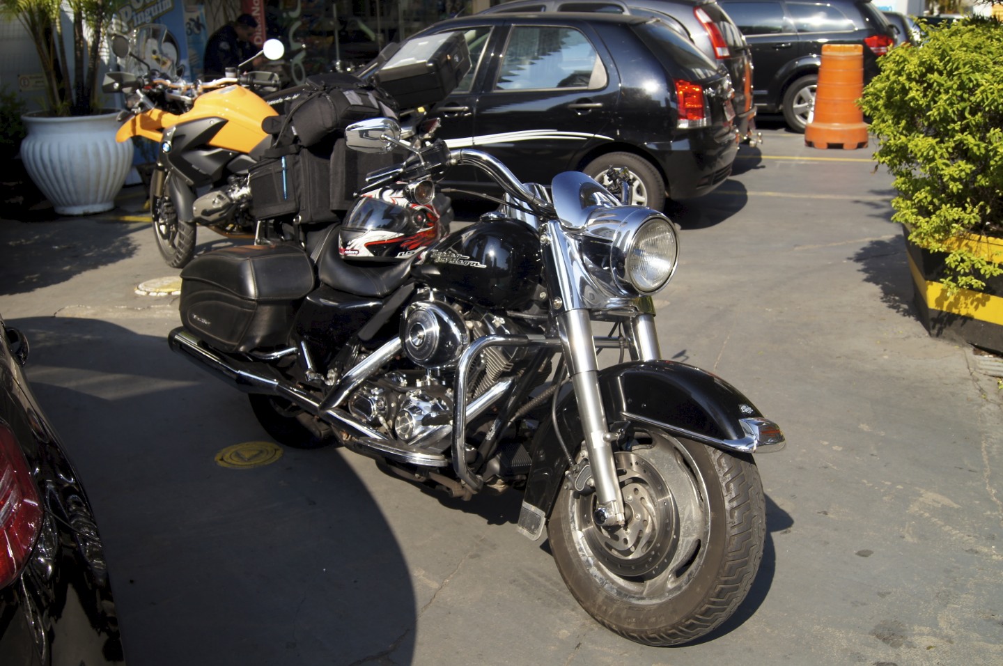 a motorcycle and a car sit in a driveway