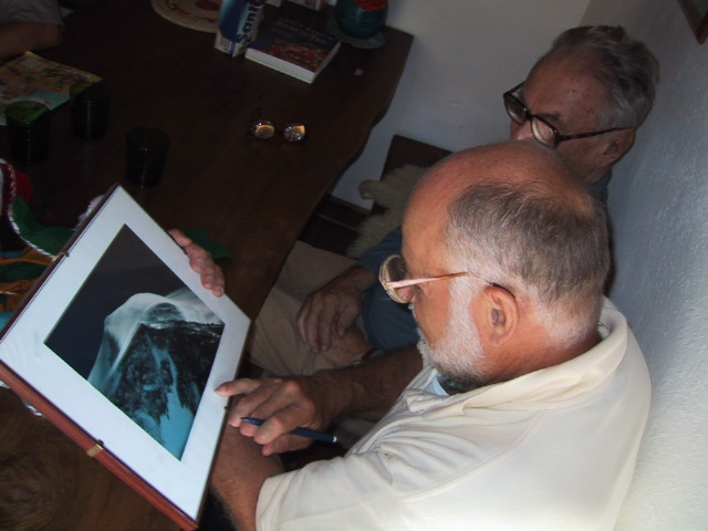 an old man sitting down and looking at a picture of a patient