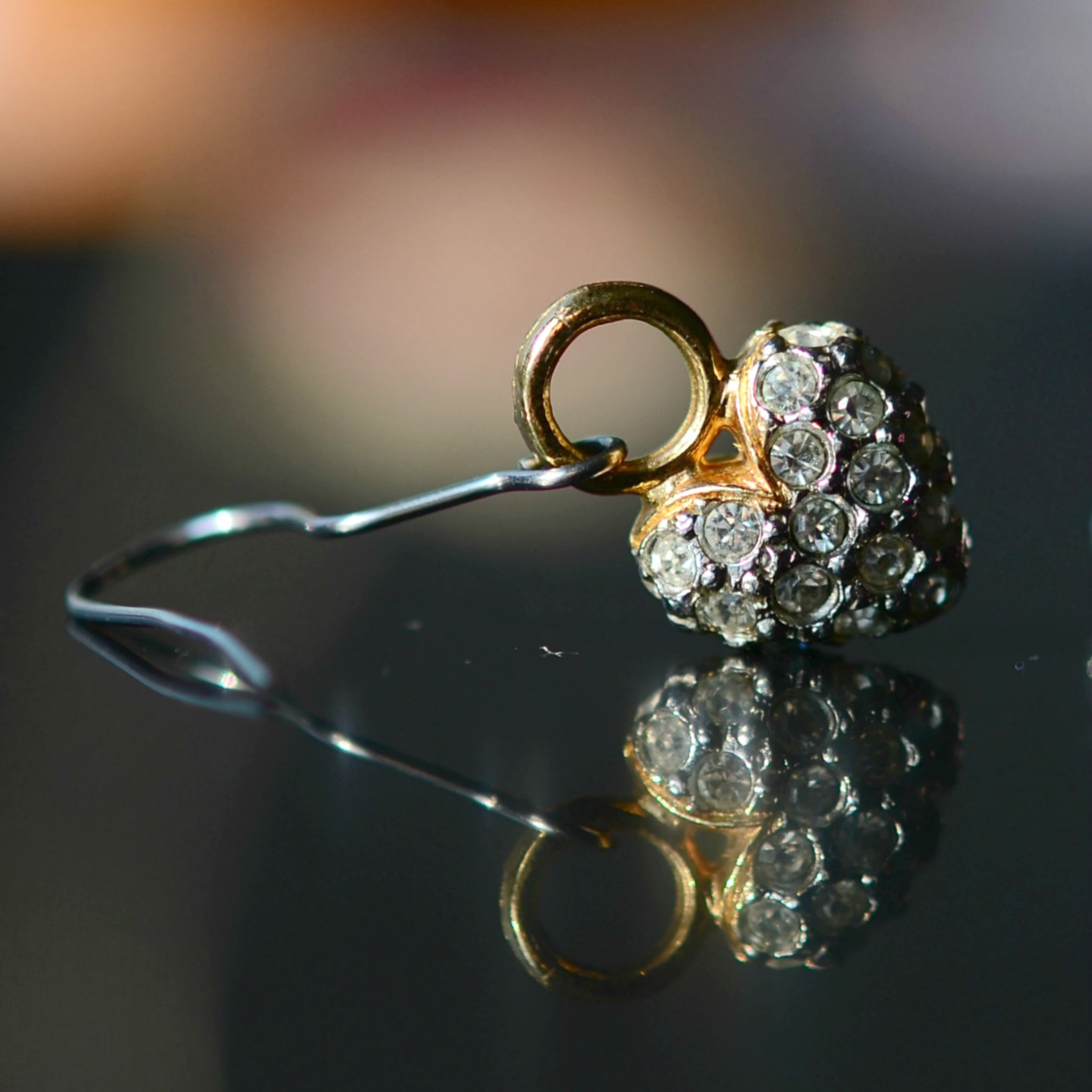 there is a gold ring and a diamond on a glass surface