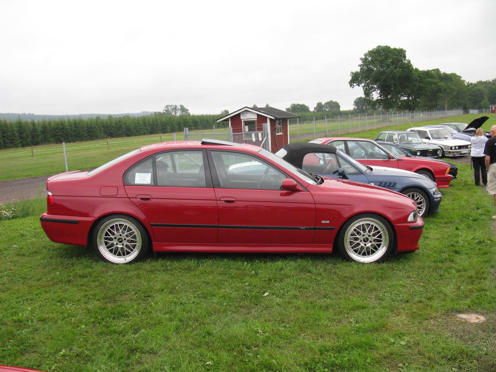 a red car parked next to several cars