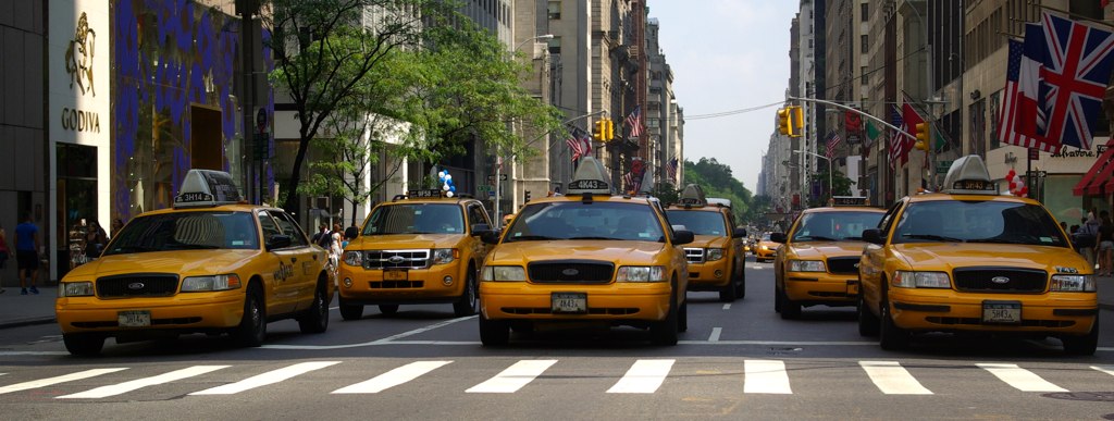 several cabs are driving down the city street